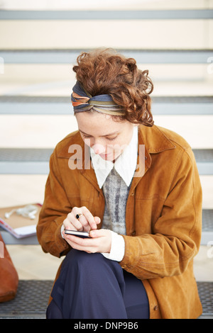 Young redhead hipster woman using smartphone outdoors Stock Photo