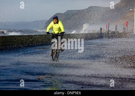 West Bay, Dorset UK. 3rd January 2014. A cyclist gets a soaking from the storm waves breaking on Dorset’s Jurassic Coast. Credit:  Tom Corban/Alamy Live News Stock Photo