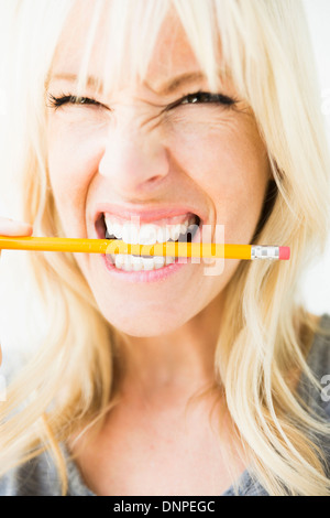 Woman holding pencil in her mouth Stock Photo