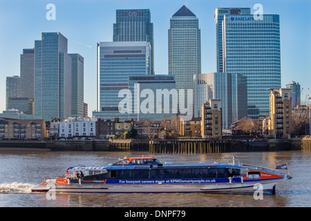 Canary Wharf and other skyscrapers on the Isle of Dogs, river Thames and boat taxi, London