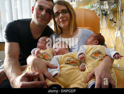 Rostock, Germany. 03rd Jan, 2014. The triplets (L-R) Till, Max and Ben lie in the arms of their parents Thomas and Marie Osswald in the South City Hospital in Rostock, Germany, 03 January 2014. Two and a half months after their birth on 22 October 2013, the triplets are now discharged home. The boys were born with a weight of 1200 to 1320 grams after only 29 weeks of gestation. Photo: Bernd Wuestneck ZB/dpa/Alamy Live News Stock Photo