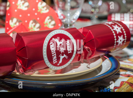 Christmas dinner table setting including a cracker on a plate Stock Photo