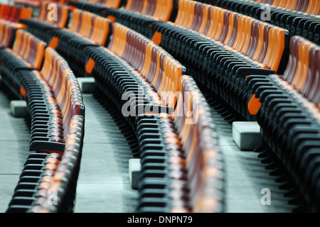 Rows of empty seats of different colors in a stadium Stock Photo