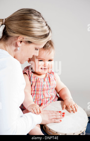 Portrait of Mother and Daughter Playing Tambourine, Studio Shot Stock Photo