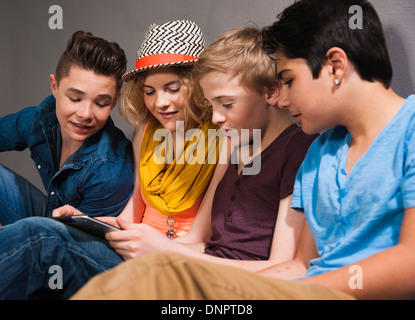 Teenagers looking at Tablet PC, Studio Shot Stock Photo