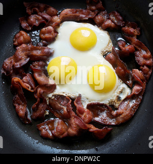 greasy frying pan full of bacon and eggs Stock Photo
