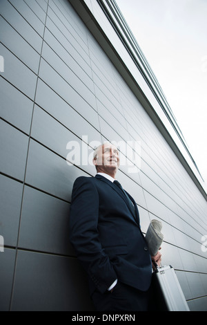 Portrait of businessman leaning against wall of building, Mannheim, Germany Stock Photo