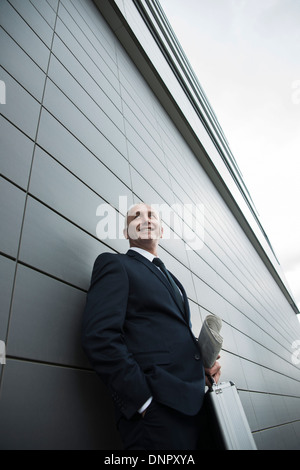 Portrait of businessman leaning against wall of building, Mannheim, Germany Stock Photo