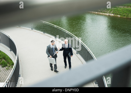 Mature businessmen on walkway talking, Mannheim, Germany Stock Photo