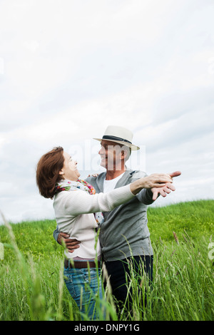 Mature couple dancing in field of grass, Germany Stock Photo