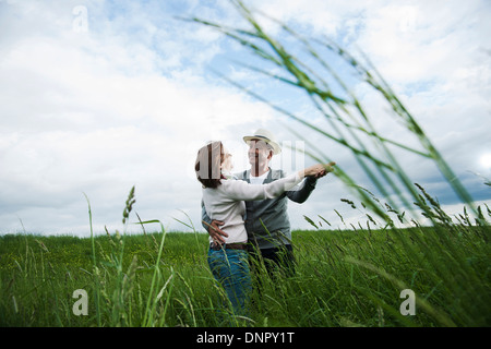 Mature couple dancing in field of grass, Germany Stock Photo