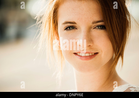 Close-up portrait of teenage girl outdoors, smiling at camera Stock Photo