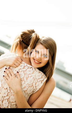Young women embracing outdoors Stock Photo