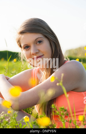 Portrait of young woman sitting in field, Germany Stock Photo