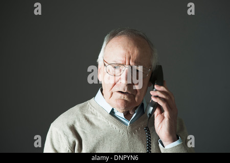 Elderly Man Talking on Phone in Studio Stock Photo