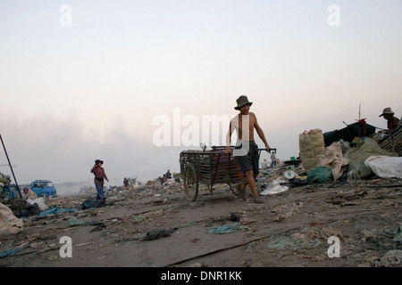A male worker is pulling a cart used for recyclable material at the toxic Stung Meanchey Landfill in Phnom Penh, Cambodia. Stock Photo