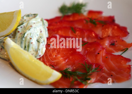 Gravlax salmon served with lemon wedges and a remoulade sauce. Stock Photo