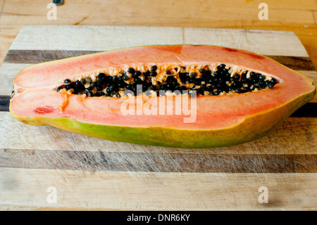 Papaya cut in half on board Stock Photo