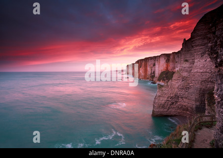 dramatic sunrise over ocean and cliffs, Etretat, France