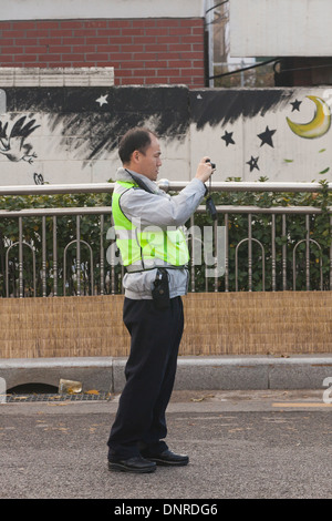 Policeman taking picture of accident scene - Seoul, South Korea Stock Photo