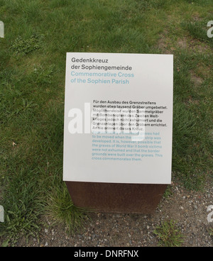 Green grass information sign about removal of graves from Sophien Cemetery, Commemorative Cross, Berlin Wall, Bernauer Strasse Stock Photo