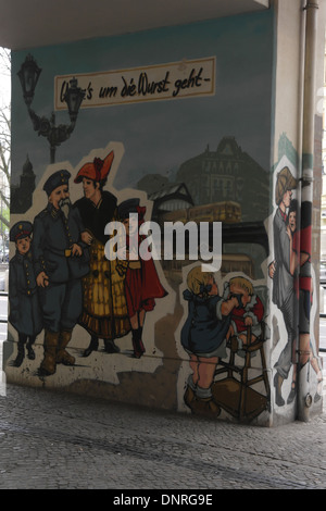 Mural 1930s courting couple, soldier family, crying baby elevated railway pillar, Konnopke's Imbiss, Schonhauser Allee, Berlin Stock Photo