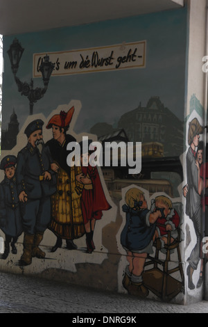 Mural 1930s soldier family, crying baby, courting couple, elevated railway pillar, Konnopke's Imbiss, Schonhauser Allee, Berlin Stock Photo