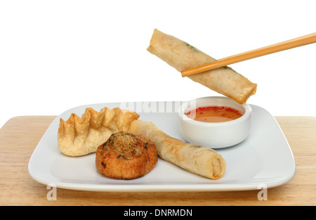 Chinese Dim Sum on a plate with a pancake roll dipping in sweet chilli sauce Stock Photo