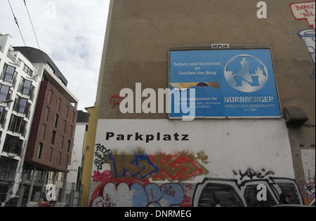 Building wall with Parkplatz name, blue billboards and painted graffiti scrawl, car park recess, Rosenthaler Strasse, Berlin Stock Photo