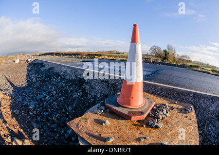 Traffic cone at the side of a newly constructed road Stock Photo