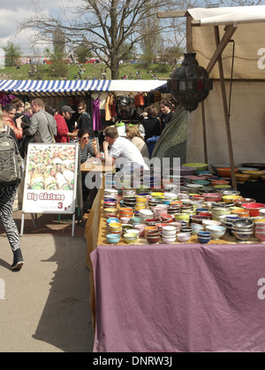 Sunny portrait colourful pots on a open-air market stall table, towards people walking, Mauerpark Flea Market, Berlin Stock Photo