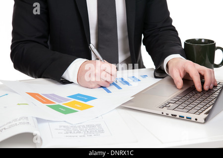 Businessman analyzing data on office desk Stock Photo