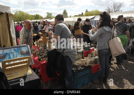 Sunny view people walking market stalls, man woman at stall selling German beer-mugs and pottery, Mauerpark Flea Market, Berlin Stock Photo