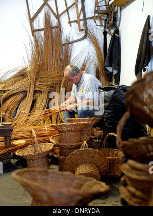 A basket weaver at work in the factory shop in Camacha Madeira Portugal Stock Photo