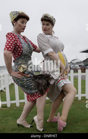 Two women posing dressed in 1950s 'char lady' costumes at Goodwood races Stock Photo