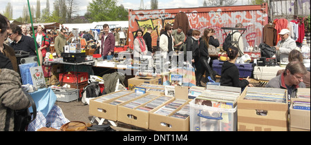 Sunny view, to graffiti containers, people walking past stall with cardboard boxes vinyl records, Mauerpark Flea Market, Berlin Stock Photo