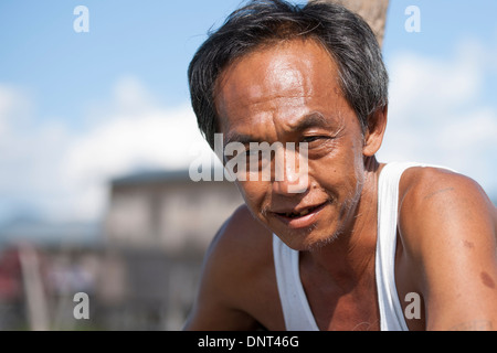Single Cheerful Asian Senior Citizen Male Man portrait outdoors in a singlet smiling on November 2, 2013 in Inle Lake, Myanmar Stock Photo