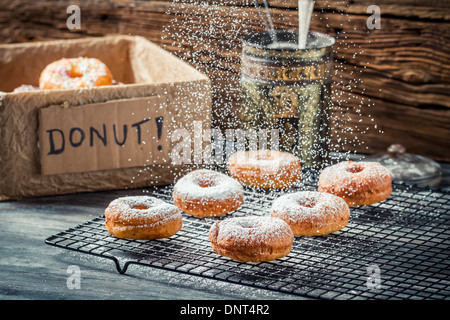 Icing sugar falling on fresh donuts Stock Photo