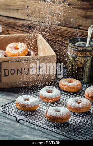 Closeup of falling powder sugar on fresh donuts Stock Photo