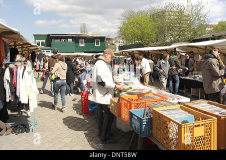 Blue sky view, to green wood building, people at open-air vinyl records and canopy clothes stalls, Mauerpark Flea Market, Berlin Stock Photo