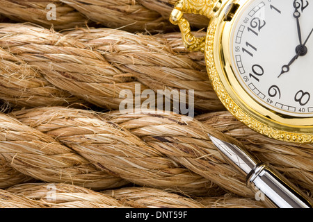 pocket watch with ink pen on ship ropes Stock Photo