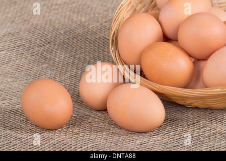 Fresh, cage-free, eggs in basket on burlap background Stock Photo