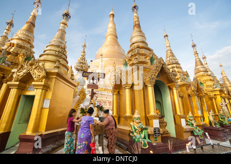 Shwedagon Pagoda devotees pour water over a Buddha  Image amongst the golden stupas on November 8, 2013, Yangon, Maynamar Stock Photo