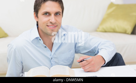 Portrait of a man with pen and book at home Stock Photo