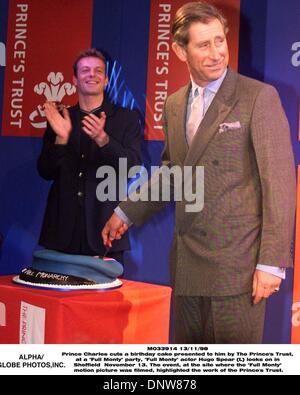 Nov. 13, 1998 - Sheffield, Great Britain - SFD13D:SHEFFIELD,ENGLAND,13NOV98 - HRH Prince Charles cuts a birthday cake presented to him by The Prince's Trust, at a ''Full Monty'' party, ''Full Monty'' actor Hugo Spear (L) looks on in Sheffield  November 13. The event, at the site where the ''Full Monty'' motion picture was filmed, highlighted the work of the Prince's Trust.(Credit I Stock Photo