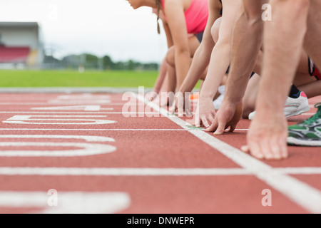 Side view of cropped people ready to race on track field Stock Photo