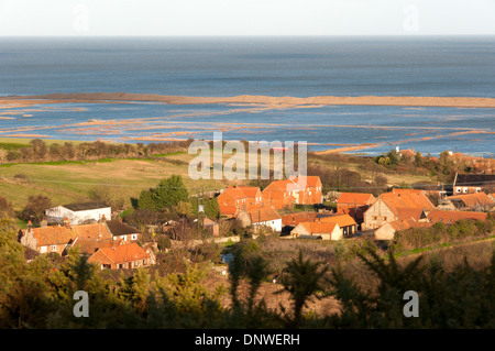 Salthouse village near Cley in North Norfolk with flooded saltmarshes between it and the shingle spit of Blakeney Point. Stock Photo