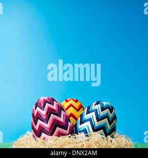 Set of colorful easter eggs in hay. Copy space. Stock Photo