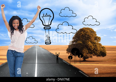 Composite image of a young happy woman stands with her hands in the air Stock Photo