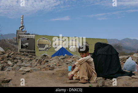 Dec 05, 2005; Balakot, PAKISTAN; Aftermath of Pakistan Earthquake on October 8, 2005. A young boy along with his mother wait near the rubble of a destroyed hotel building in Balakot, Pakistan. Mandatory Credit: Photo by Nelvin Cepeda/San Diego Union T/ZUMA Press. (©) Copyright 2005 by San Diego Union T Stock Photo